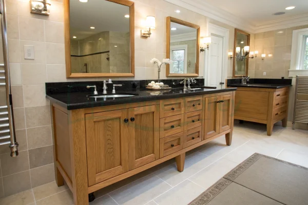 Double sink bathroom vanity with black countertop and natural wood cabinetry in a spacious tiled bathroom