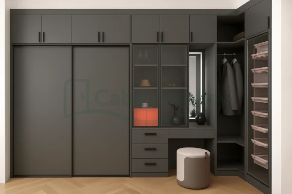 Full-wall L-shaped wardrobe with matte black sliding doors, glass shelving, and open hanging compartments, paired with a vanity and modular drawers.