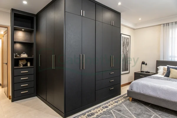 Modern black wardrobe with open shelves and drawers, integrated into a compact bedroom corner