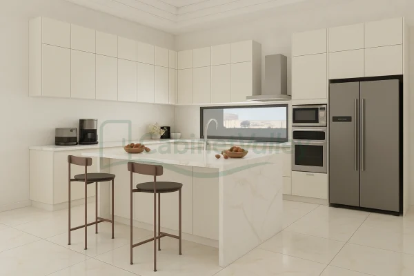 Glossy white L-shaped kitchen with marble island and handle-free minimalist cabinetry under natural light.
