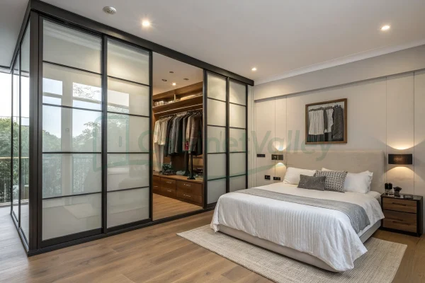 Minimalist bedroom design with a corner-mounted sliding wardrobe in frosted glass and black trim, showcasing warm wood interiors, drawers, and a panoramic window view.