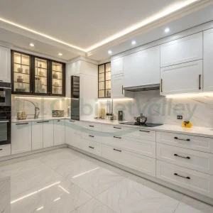 Bright white kitchen with handle-free cabinets, LED lighting, and built-in appliances in a contemporary layout.