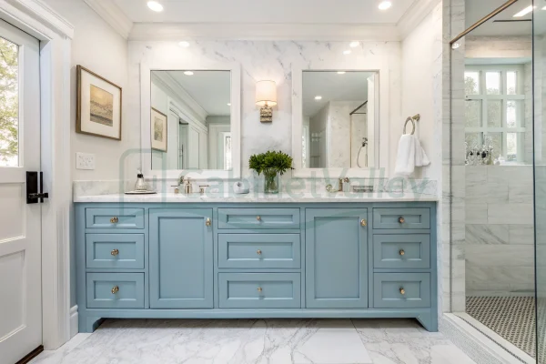 Elegant glossy blue bathroom cabinet set with twin sinks and gold hardware in marble surroundings