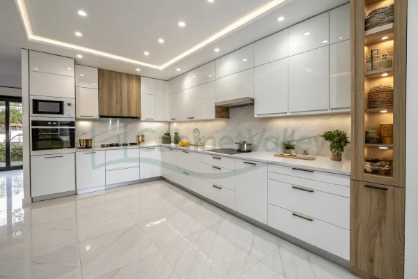 Elegant minimalist kitchen with sleek white cabinetry, black pulls, and marble-pattern backsplash.