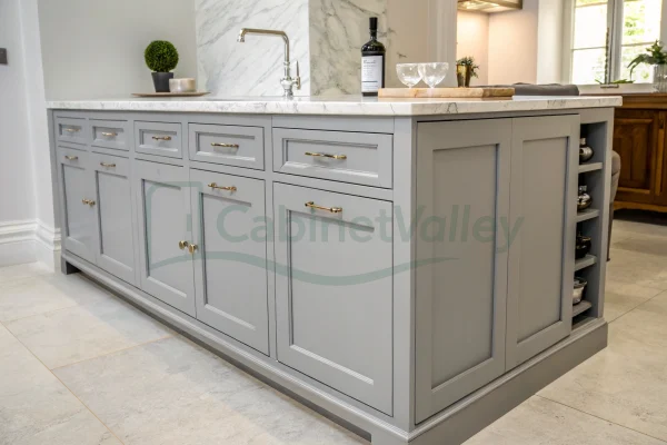 Long gray cabinet system with dual sinks, marble top, and brass accents in a transitional bathroom